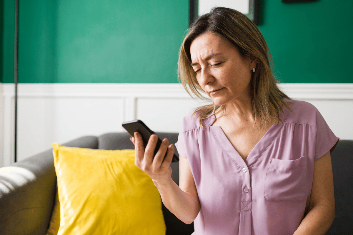 an older woman having trouble seeing while looking at her phone