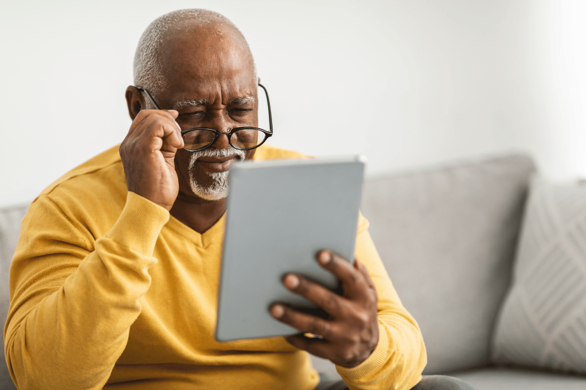 an older man having trouble reading on his tablet