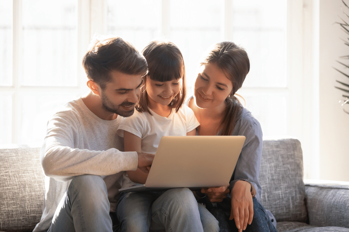 A family at home looking at a computer together